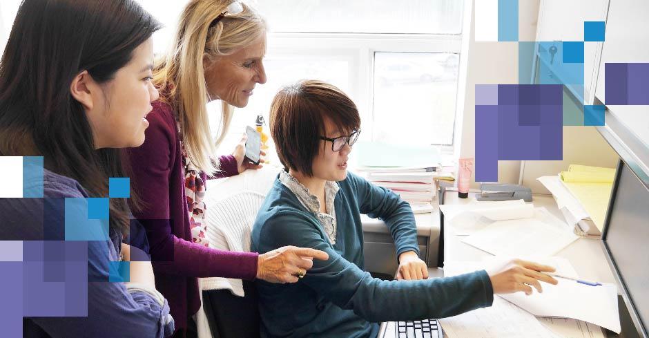 faculty member and student pharmacists reviewing data on computer screen