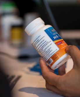 closeup of hand holding a medication bottle