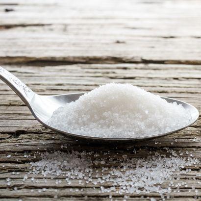 spoon of sugar and sugar cubes on a table