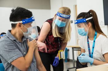 Clinard shows two students how to administer a vaccine.