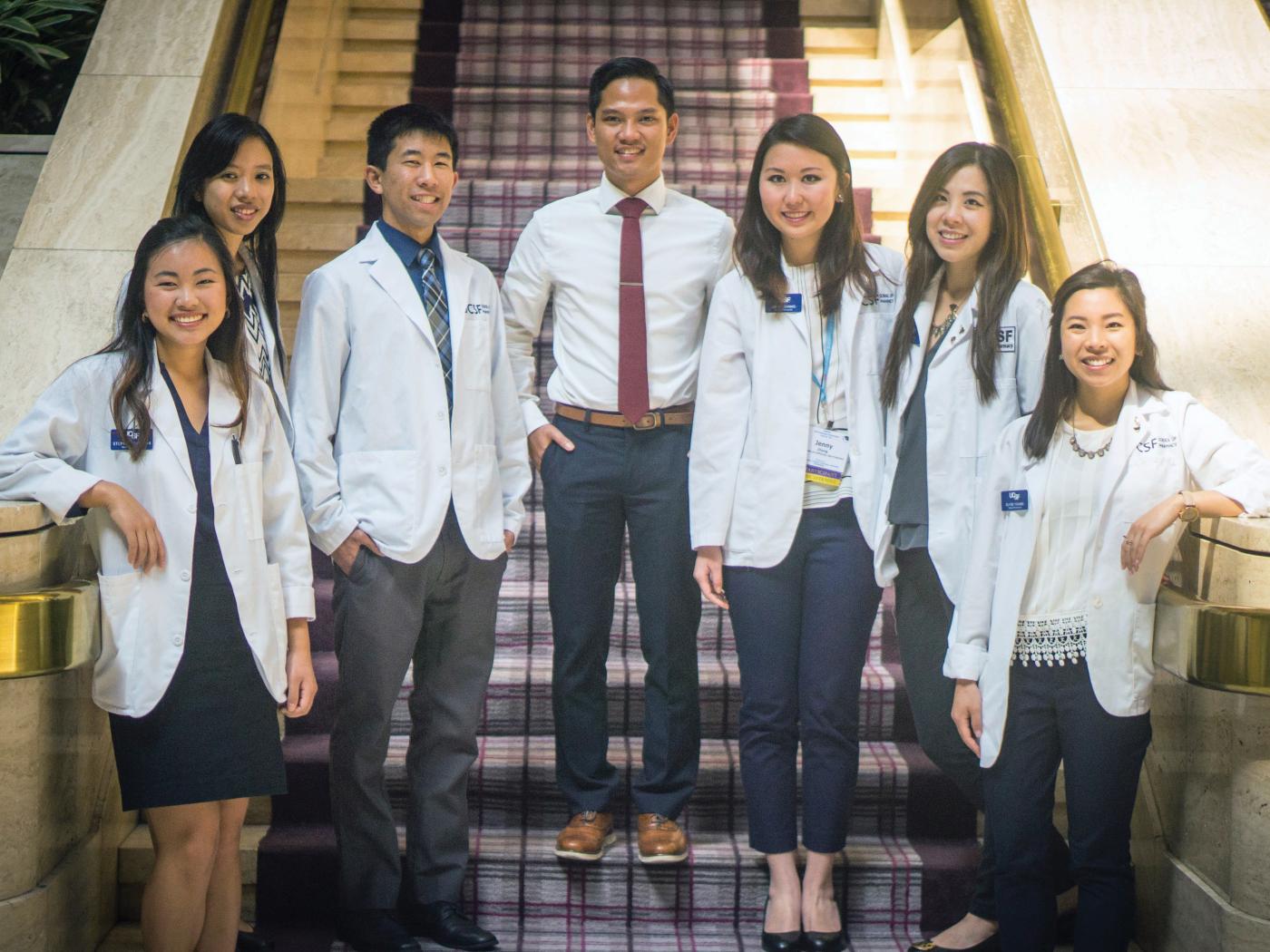 seven team members dressed in white coats.